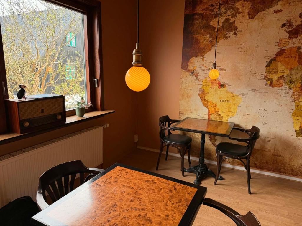 a dining room with a table and chairs and a window at Guesthouse Leon - Historic Home Near City Center with Free Parking in Tórshavn
