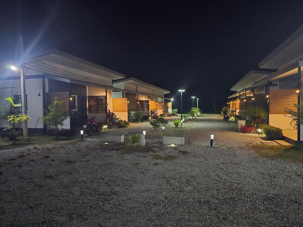 a row of buildings at night with lights at แวะมาพักโคกกลอย Wae Ma Phak Khokkoi in Ban Huai Sai