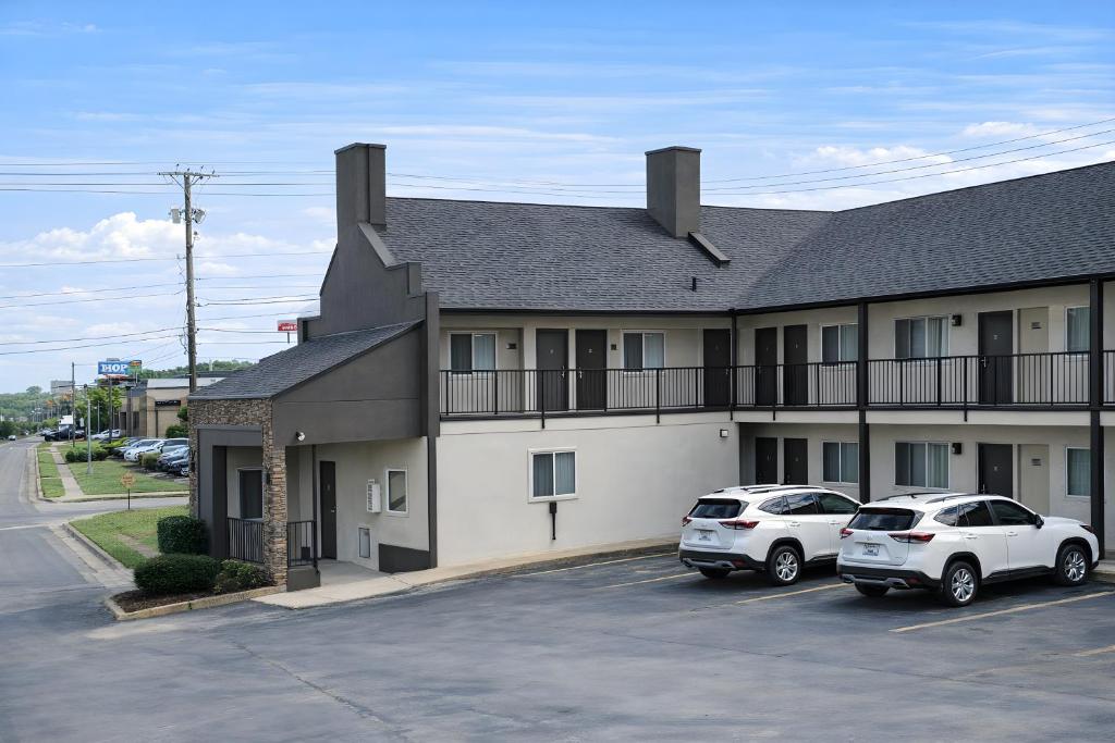 a building with two cars parked in a parking lot at Quarters Inn & Suites in Antioch