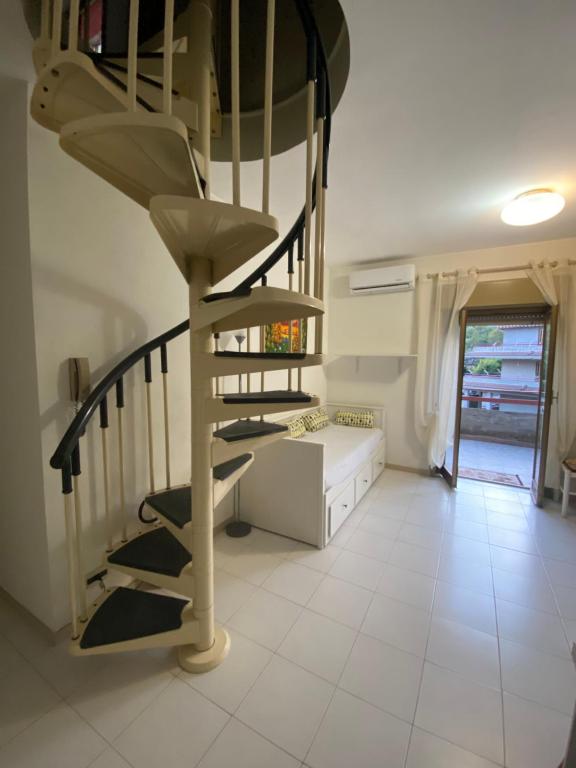 a spiral staircase in a room with a white tile floor at La mia casetta in Taormina