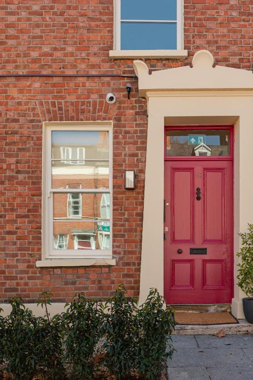 a red door on the side of a brick building at Check In Belfast in Belfast