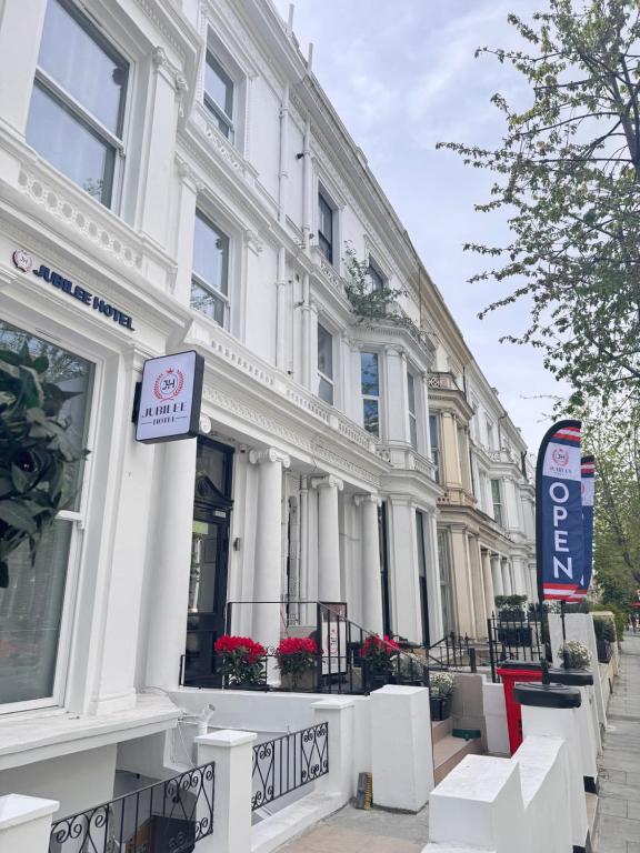 a white building with a sign in front of it at Jubilee Hotel Kensington in London