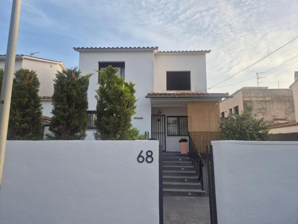 a white house with a gate in front of it at Sitges Casablanca in Sant Pere de Ribes