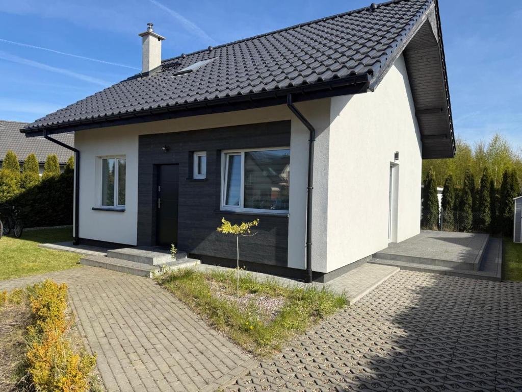 a small house with a black and white at Domek in Kamień Pomorski