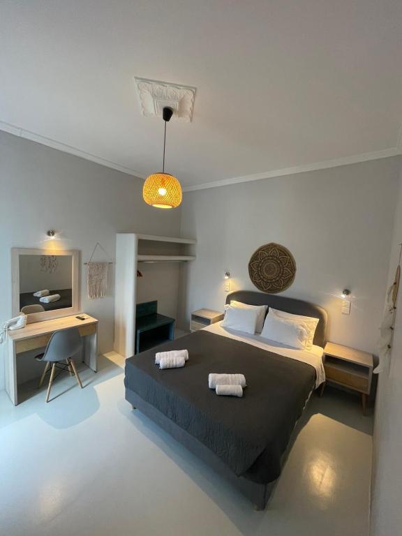 a bedroom with a bed and a desk with a computer at Passos Rooms in Parikia
