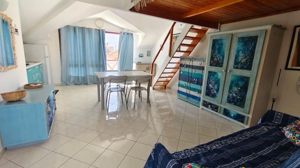 a living room with a table and a staircase at Holiday Properties, Ilha do Fogo in Santa Maria