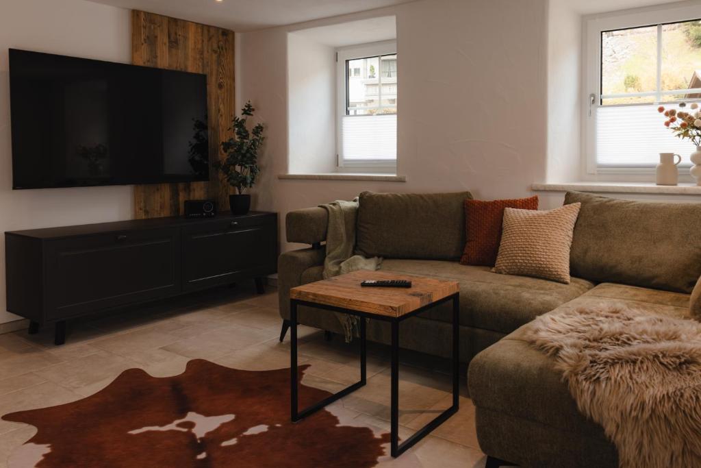 a living room with a couch and a flat screen tv at Chalet Ferienwohnung zwischen Berchtesgaden und Ramsau in Bischofswiesen