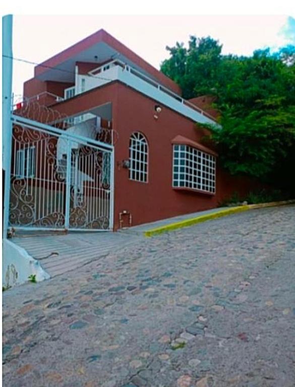 a red building with a gate in front of it at Best area and ocean view in Cruz de Huanacaxtle