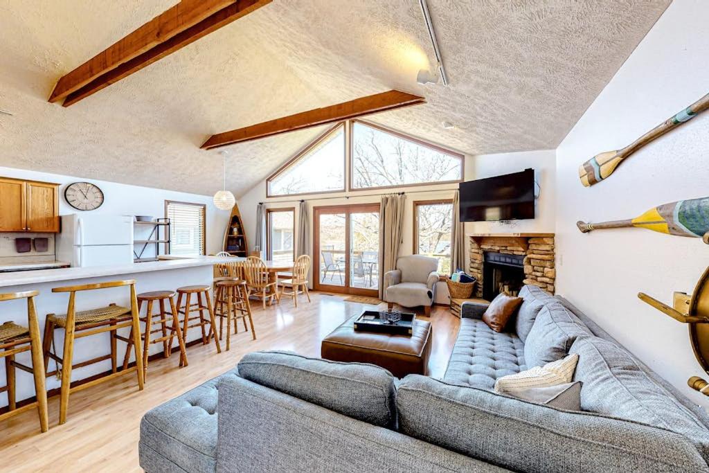 ein Wohnzimmer mit Sofa und Tisch und eine Küche in der Unterkunft Farmer's Getaway in Reeds Spring