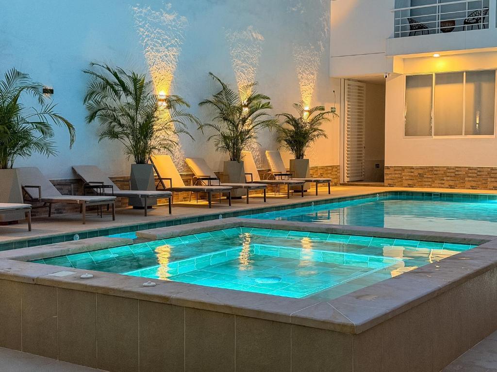 a swimming pool with tables and chairs next to a building at Palmará Hotel in Villeta