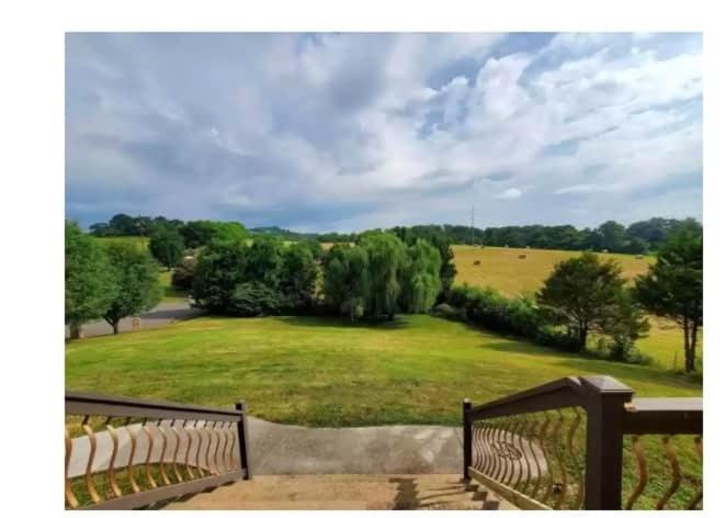 a balcony with a view of a large green field at Spacious 4 bd with hottub, theater & game zone in Union Grove