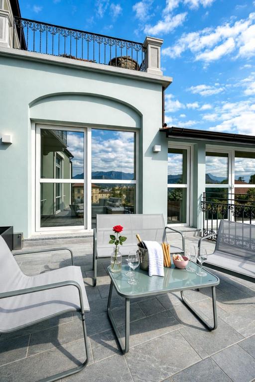 a patio with a table and chairs and a house at Apt. Aquarius Oasi di Menaggio in Menaggio