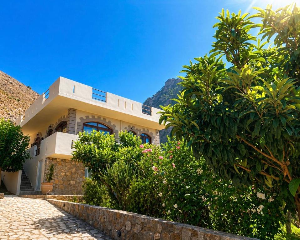 a house with a mountain in the background at Artemisa House in Agia Roumeli