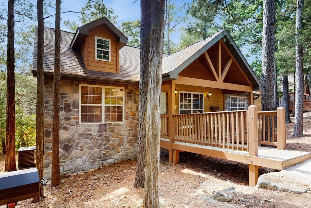 a log cabin in the woods with a large porch at Woodland in Branson West