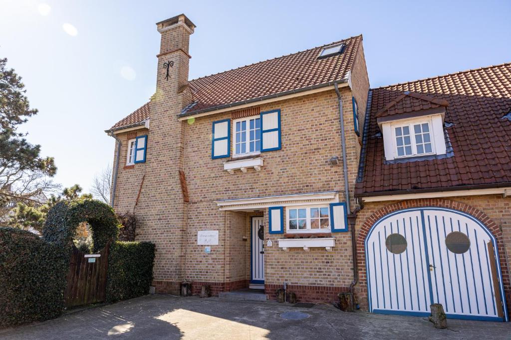 a large brick house with a white garage at B&B Dreamcottage in Knokke-Heist