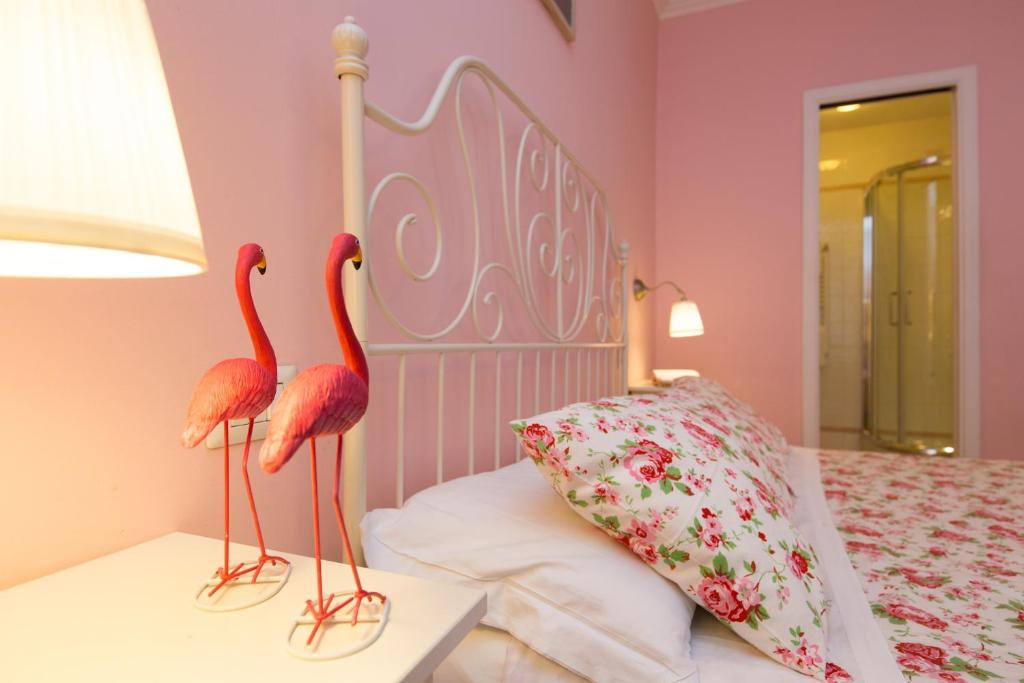 two pink flamingos on a bed in a pink bedroom at Malkavacanze B&B in Rome