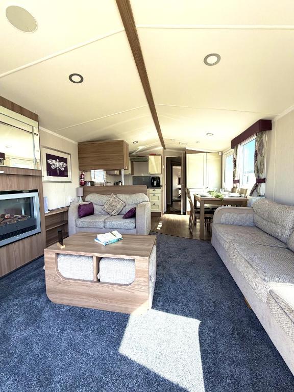 a living room with a couch and a table at Primrose View in Filey