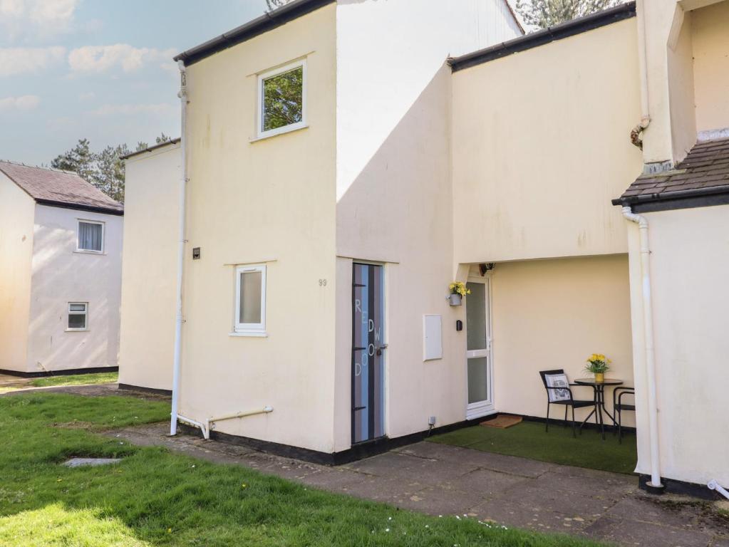 a white house with a patio and a table at Redwood in Harlech