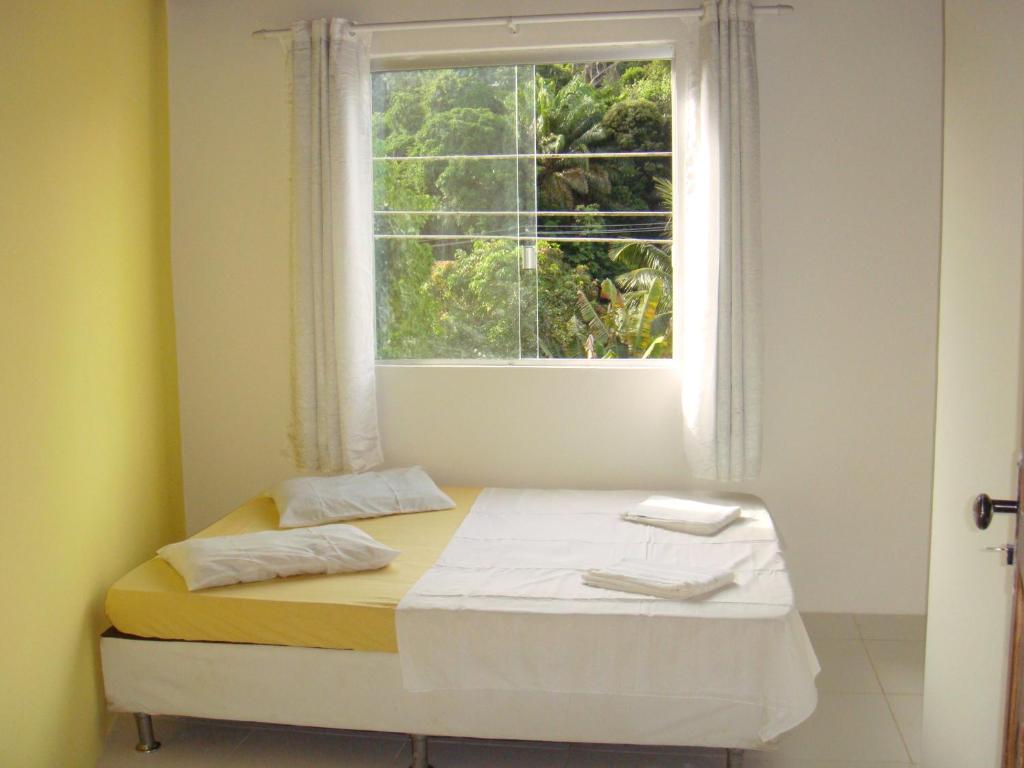 Cama en habitación con ventana en Pousada Guest House Rota 027 Morro de São Paulo, en Morro de São Paulo