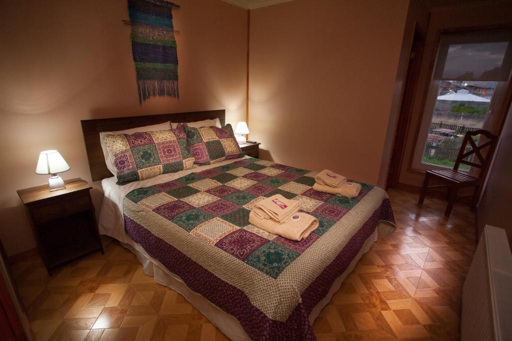 a bedroom with a bed with two towels on it at Cordillera Azul in Puerto Natales