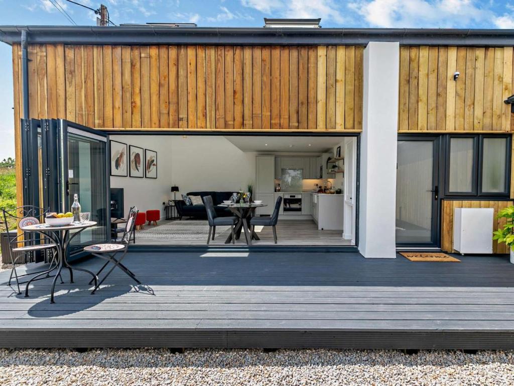 a house with a wooden deck with a table and chairs at 1 Bed in Redruth oc-92281 in Redruth