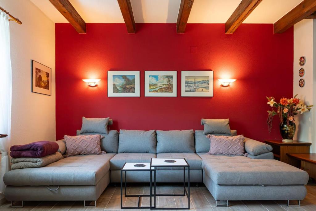 a living room with a couch and a red wall at 100 m2 Familien 4-Zimmer Apartment mit Terrasse und Burgblick und gratis parken in Maria Enzersdorf
