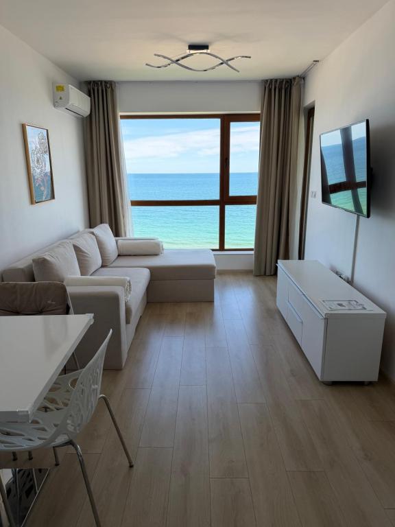 a living room with a couch and a view of the ocean at Kabakum See infinity in Varna City