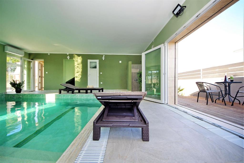 a swimming pool with a bench in a house at Villa Roko in Vir