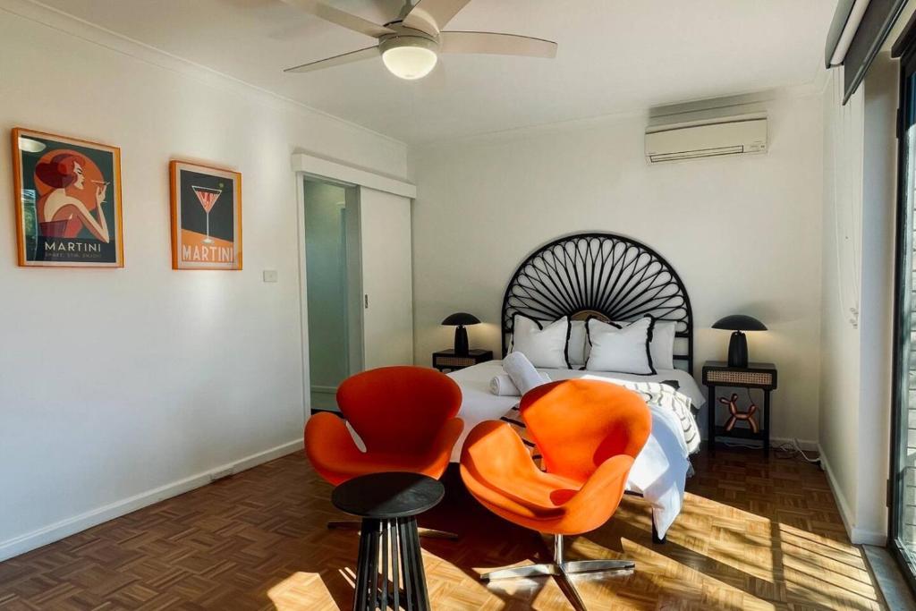 a bedroom with a bed and two orange chairs at The Newton in Lyons