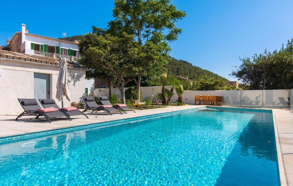 a swimming pool with chairs and a house at Mater Randa in Algaida