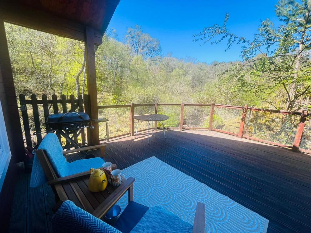 a porch with a bench and a swing on a deck at Garden Cabin at Shengan in Banavie