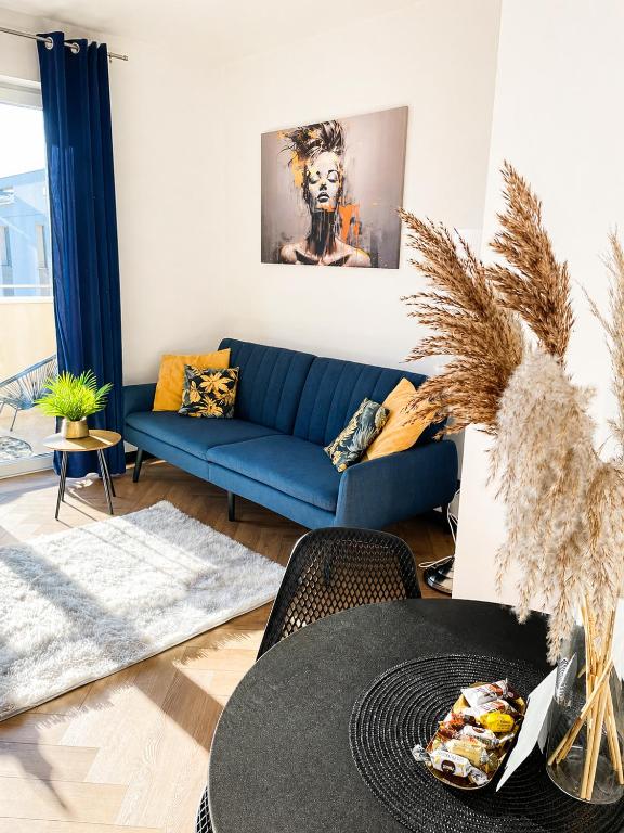 a living room with a blue couch and a table at Ami Luxury Residence XII CENTRUM - parking in Iława