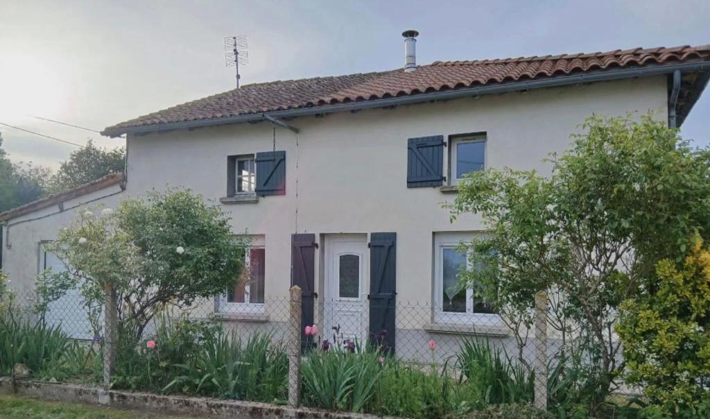a white house with a fence in front of it at Gîte Chez Dédé in Brillac