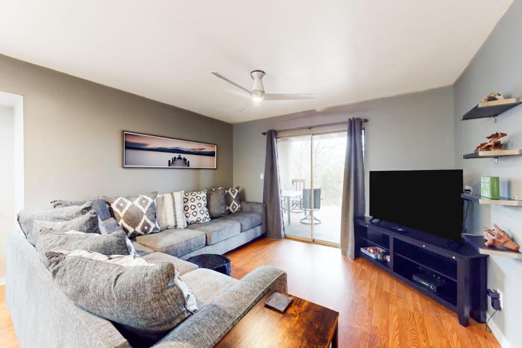 a living room with a couch and a flat screen tv at The Adventure Pad, Unit 1 in Branson