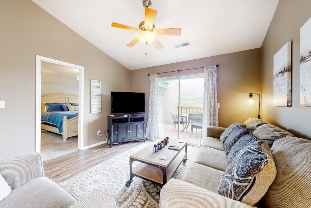 a living room with a couch and a ceiling fan at Lake Adventures at Eagle's Nest in Branson