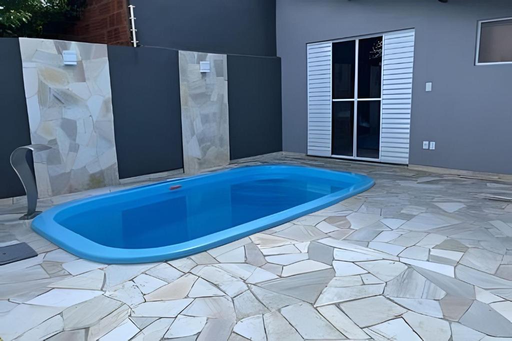 a large pool in a room with a tile floor at Casa do Bruno, 600 mt do thermas in Olímpia