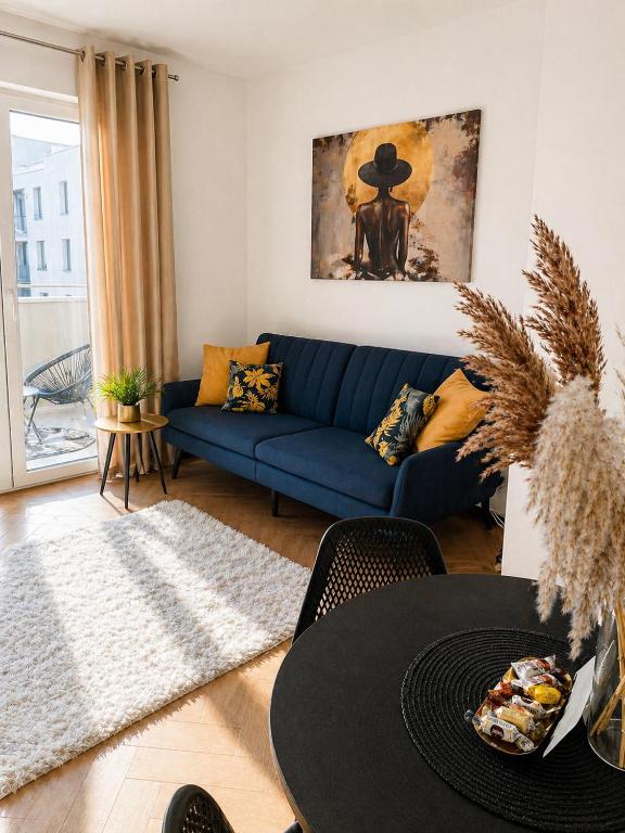 a living room with a blue couch and a table at Ami Luxury Residence VI CENTRUM - parking- in Iława