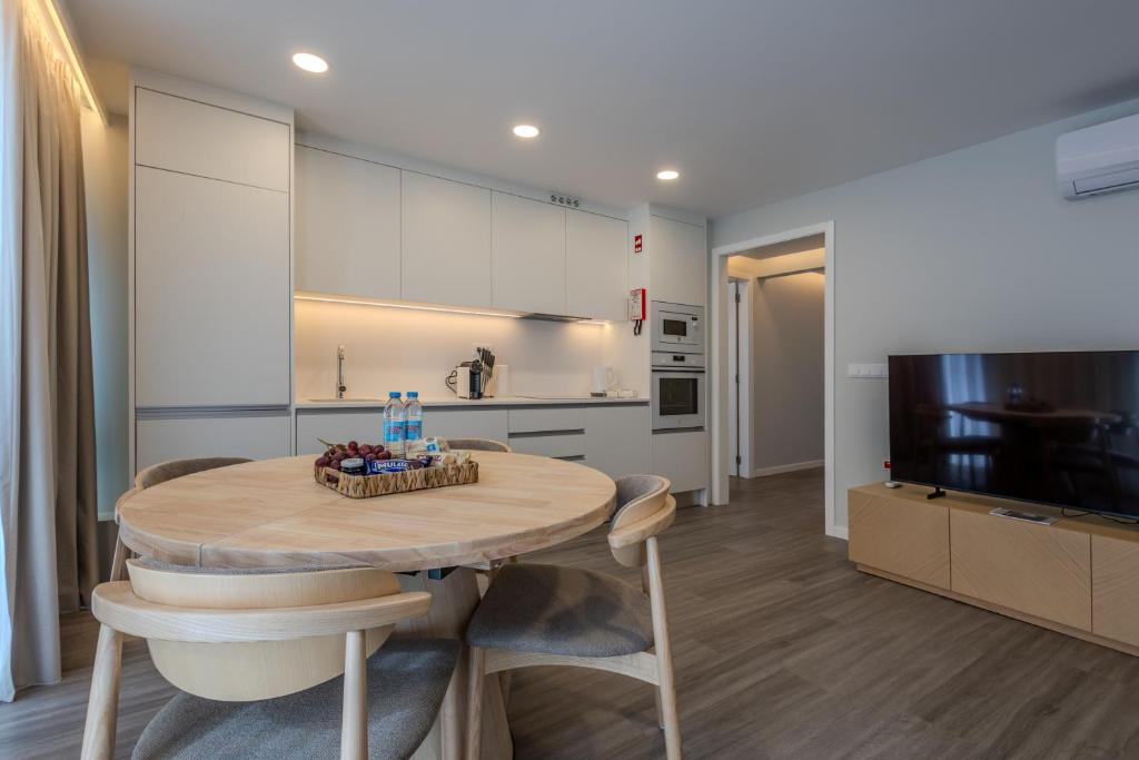 a kitchen and dining room with a table and a television at Azor Signature Flats - IV in Ponta Delgada