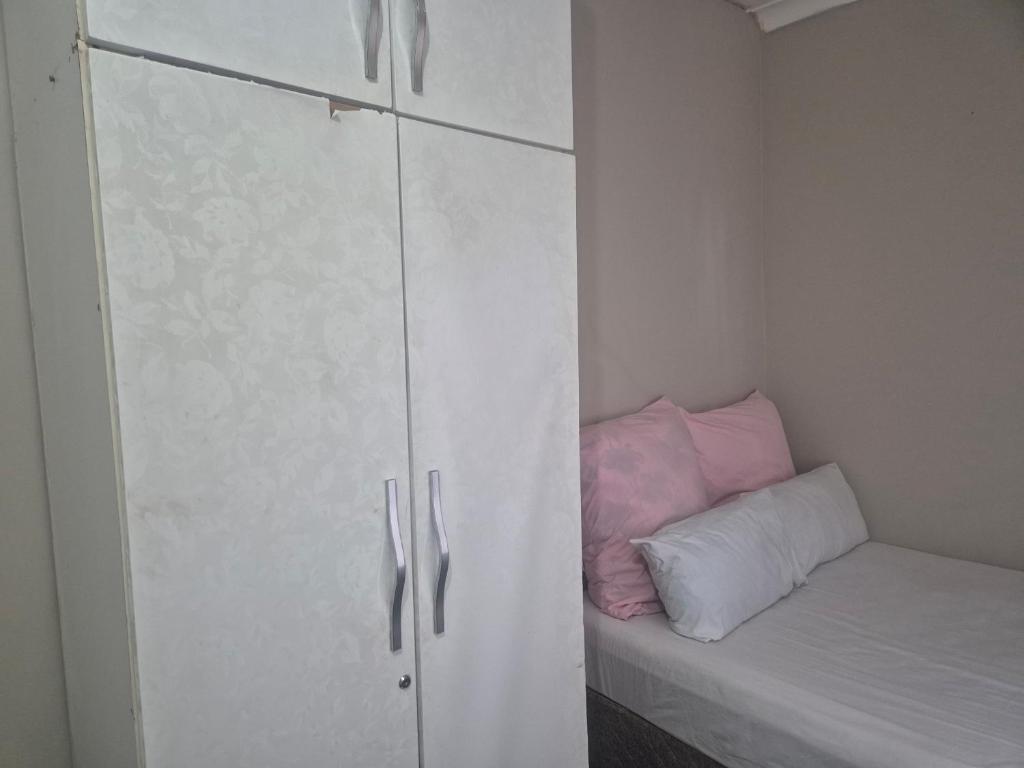 a bedroom with a white cabinet and a pillow at BluSash in Durban