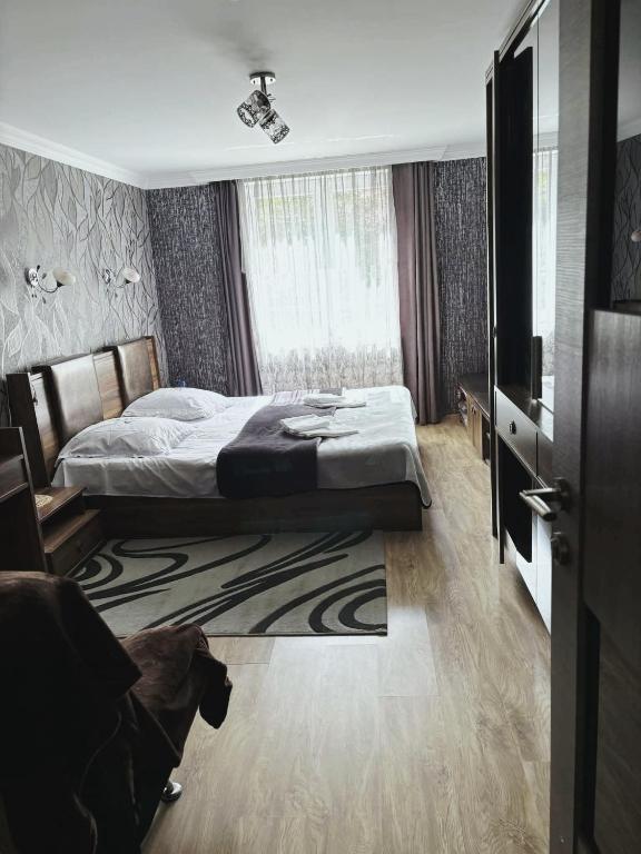 a bedroom with a bed and a large window at Dachi Apartment in Sighnaghi