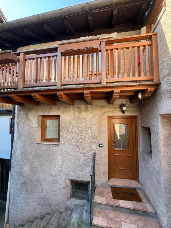 a house with a wooden deck over a door at Casa singola zona pedonale Fiera di Primiero in Fiera di Primiero