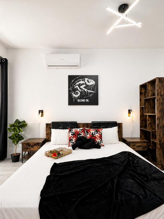 a bedroom with a large bed with a black blanket at Occo by the Pool in Popeşti-Leordeni