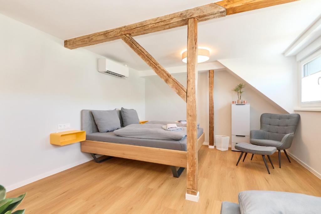 a living room with a bed and a chair at Burgblick Appartement Riesling Gold in Bernkastel-Kues