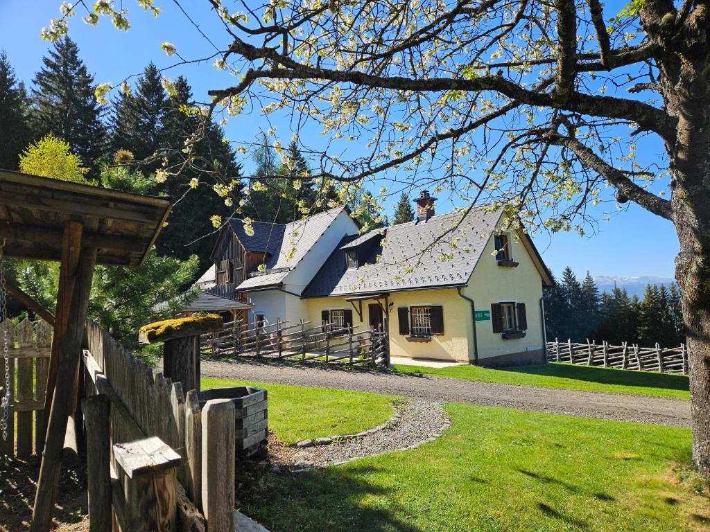 a white house with a fence in front of it at Almhütte, Ferienhaus Hadn Hube in Paisberg