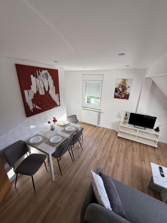a living room with a table and chairs and a television at StayKassel Apartment in Kassel