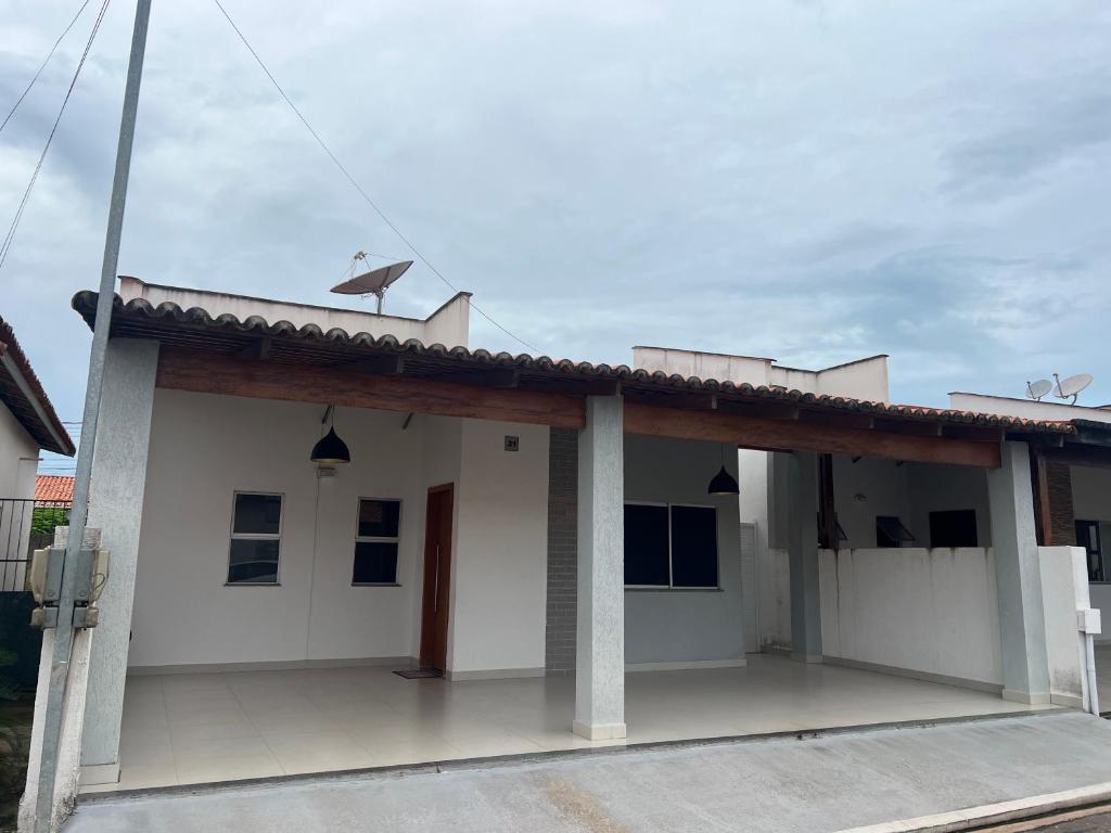a small white house with a roof at Casa aconchegante in Imperatriz