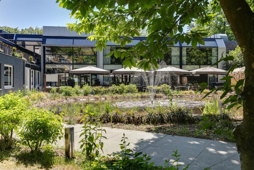 a garden with a fountain in front of a building at Hotel Landgoed Zonheuvel in Doorn