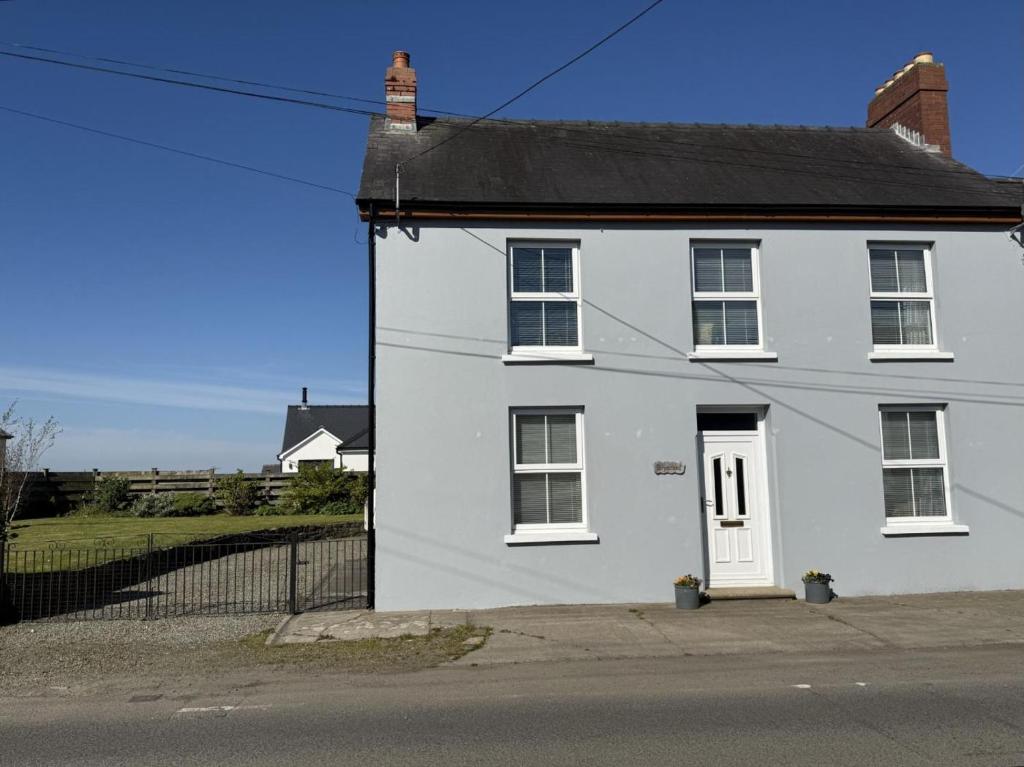 a white house with a white door on a street at 3 Bed in Narberth oc-79443 in Narberth