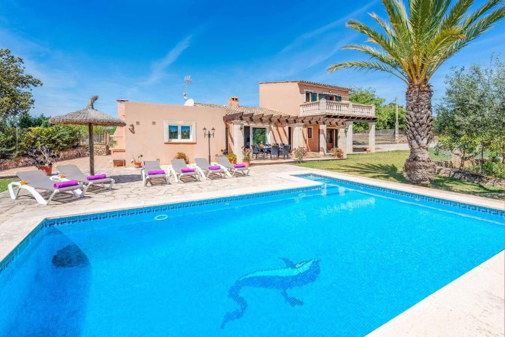 a swimming pool in front of a house with a dolphin in the water at Casa Catalina in Felanitx