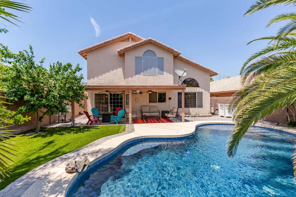 a house with a swimming pool in front of a house at Chandler Oasis in Chandler
